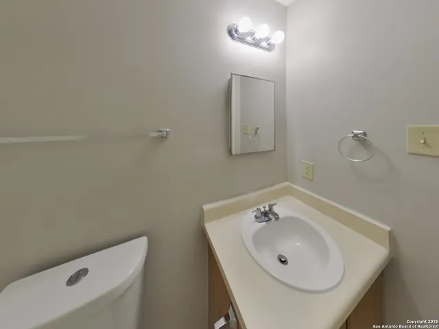 a bathroom with a sink a toilet and a mirror