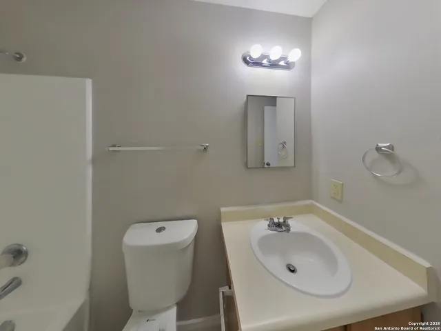 a bathroom with a sink and mirror with toilet