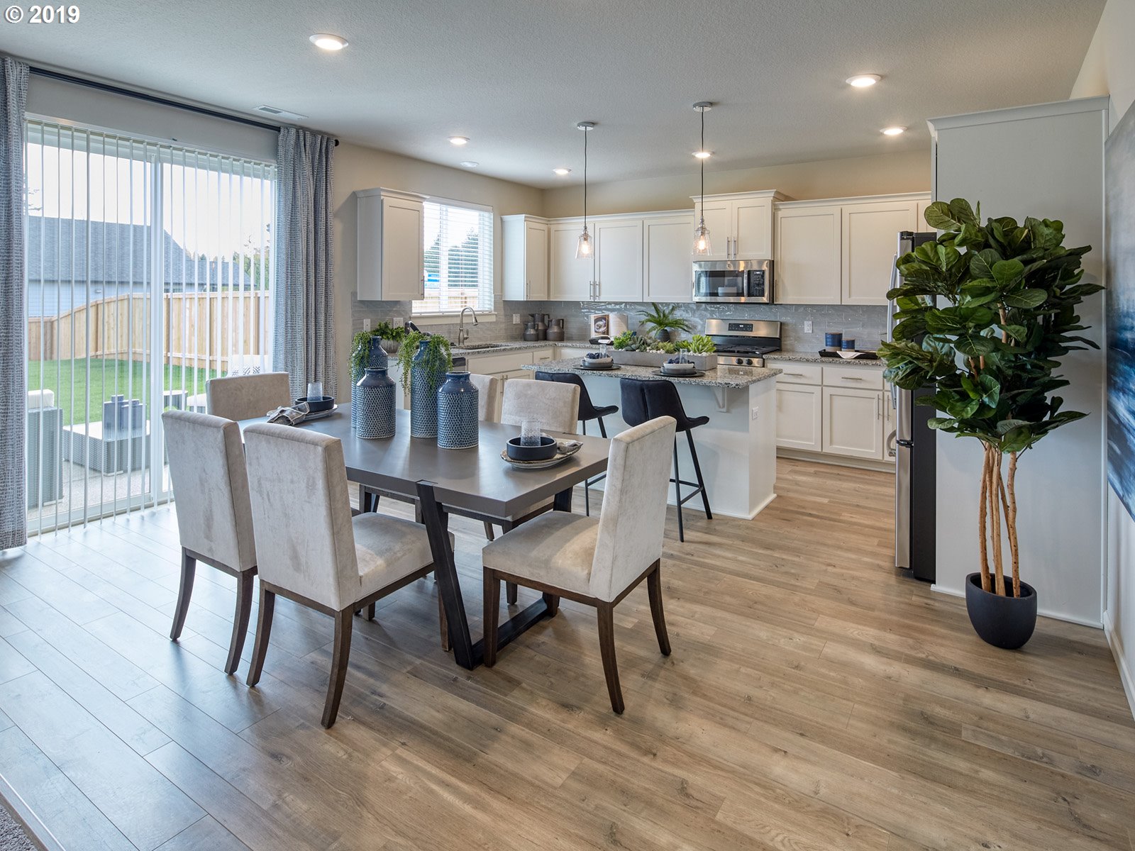 4099 Southwest Rodlun Road Gresham, OR 97080 - Photo 10 of 30 a kitchen with stainless steel appliances granite countertop a table chairs refrigerator microwave and cabinets