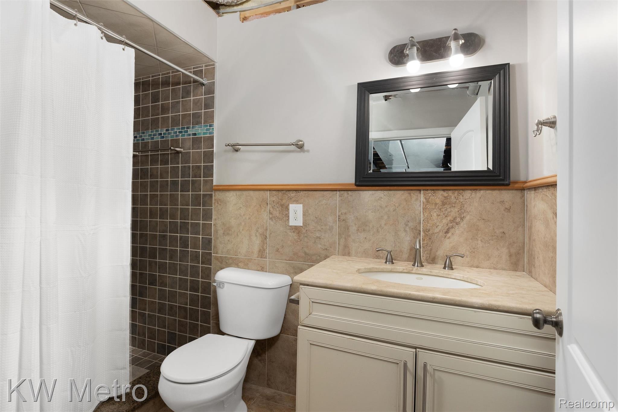 65884 Windrose Court Ray, MI 48096 - Photo 75 of 82 Basement bathroom featuring vanity, a stall shower, and tile walls