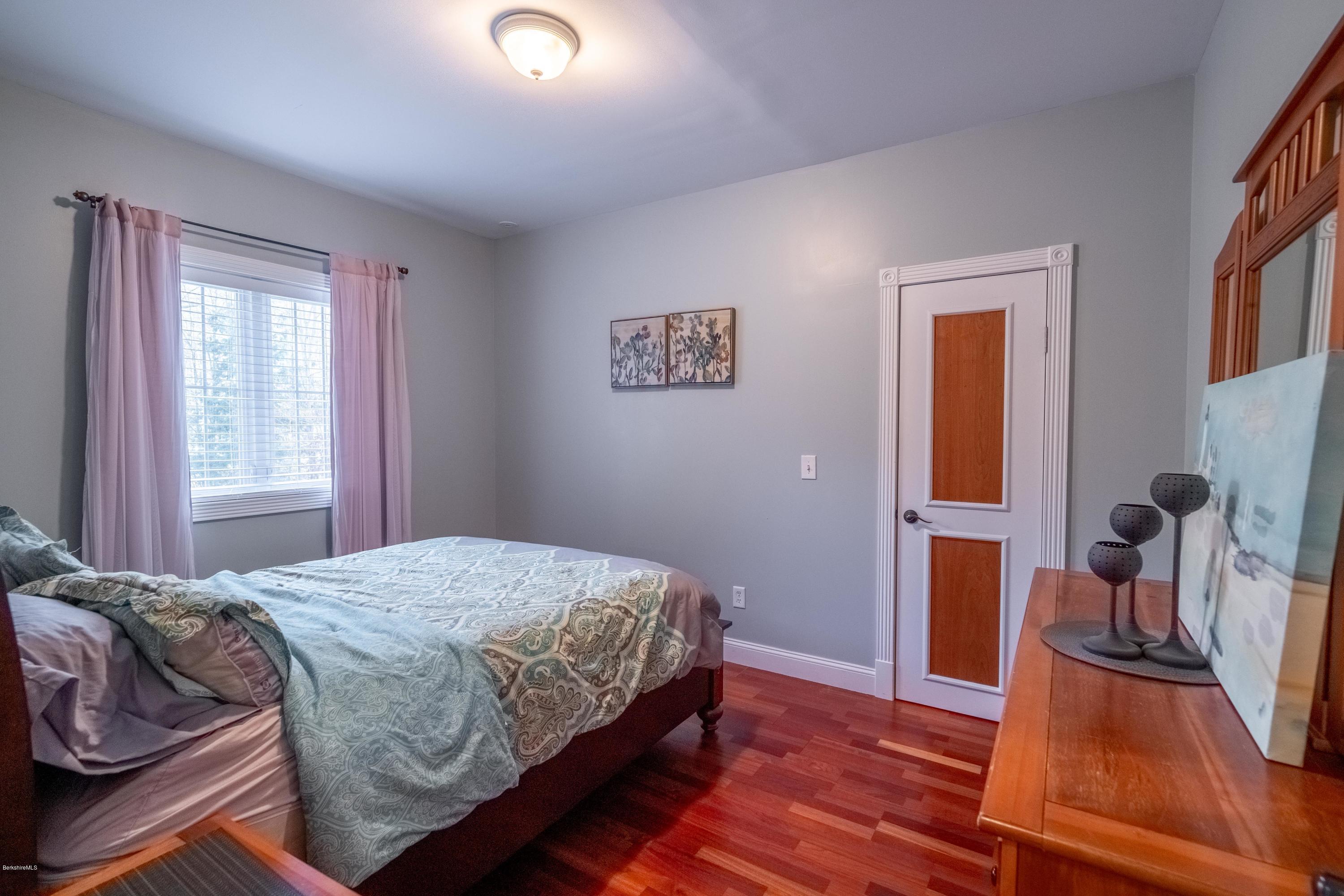 29 Valley View Road Becket, MA 01223 - Photo 12 of 36 a bedroom with a bed and a wooden floor