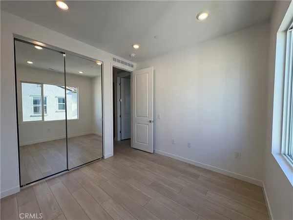 an empty room with wooden floor and mirror