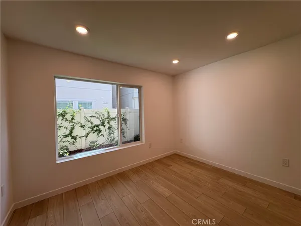 an empty room with wooden floor and window