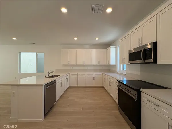 a kitchen with white cabinets and stainless steel appliances