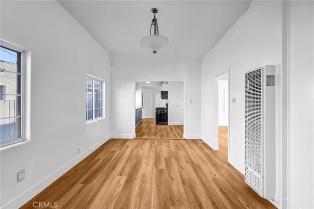 a view of a bedroom with wooden floor and a window