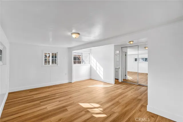 a view of empty room with wooden floor and window