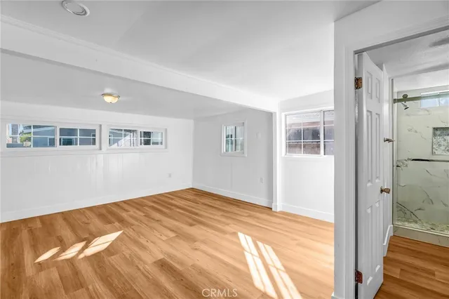 a view of a bedroom with wooden floor and a bathroom