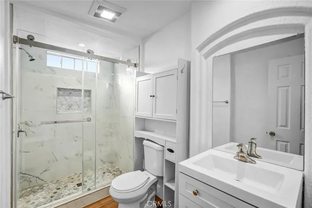 a bathroom with a sink a toilet and shower