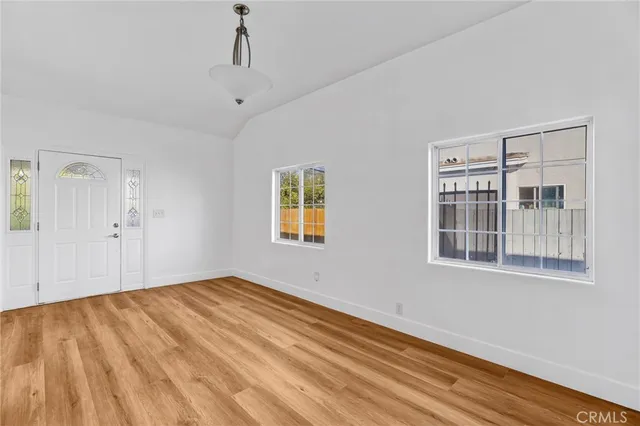 a view of empty room with wooden floor and windows