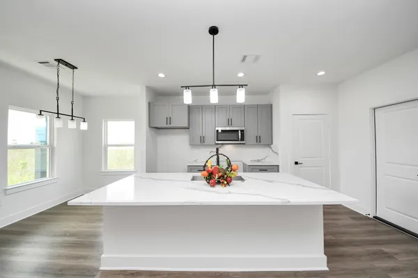 a kitchen view with living room and windows