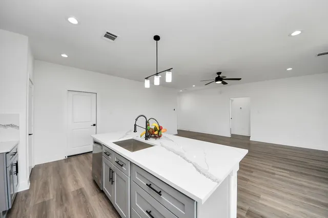 a kitchen that has a lot of cabinets and wooden floor