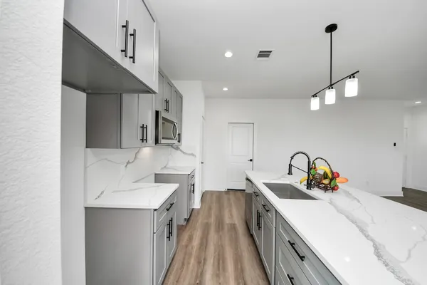 a kitchen with a sink stove and cabinets