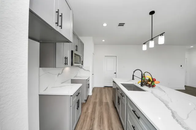 a kitchen with a sink stove and cabinets
