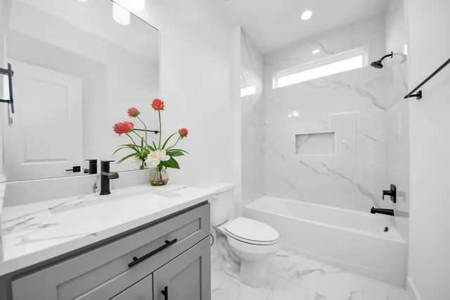 a bathroom with a granite countertop sink a toilet and a bathtub