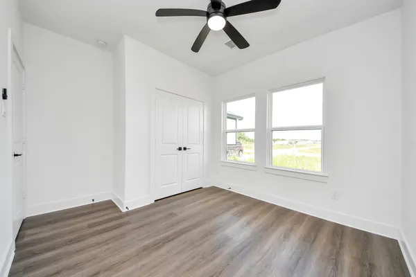 a view of empty room with wooden floor and window
