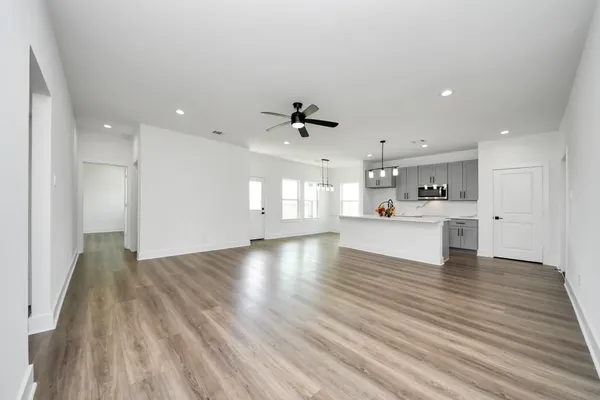 a view of an empty room with window and wooden floor