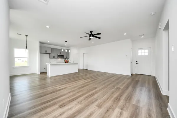 a view of a kitchen with wooden floor and a ceiling fan