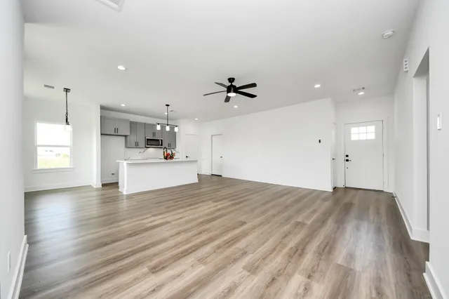 a view of a kitchen with wooden floor and a ceiling fan
