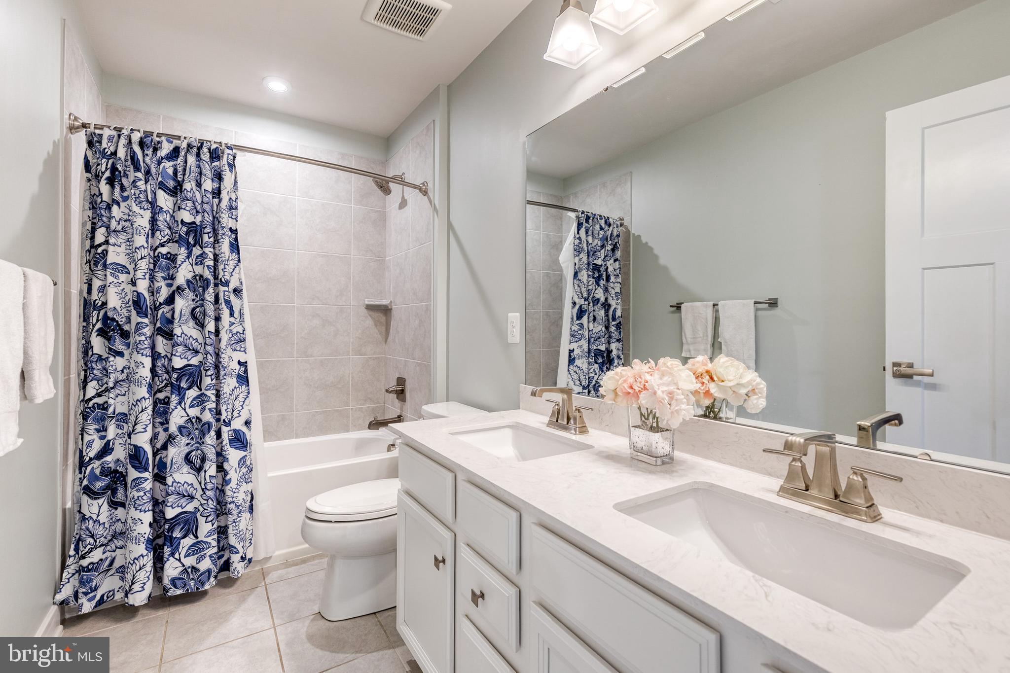 6003 Valentine Way Hanover, MD 21076 - Photo 43 of 52 a bathroom with a double vanity sink toilet and shower
