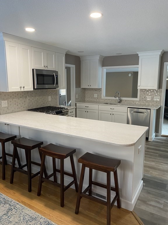 30 Hampton Knolls Road Holyoke, MA 01040 - Photo 6 of 38 a kitchen with stainless steel appliances granite countertop a dining table chairs and sink