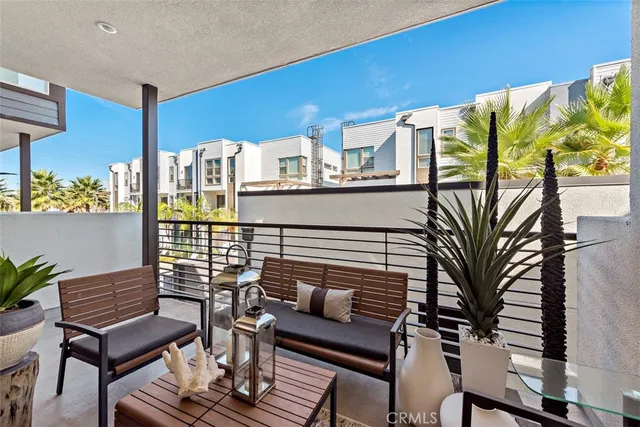 a living room with furniture a potted plant and a floor to ceiling window