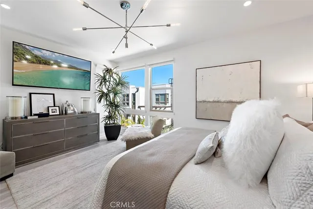a bedroom with a large bed and a chandelier