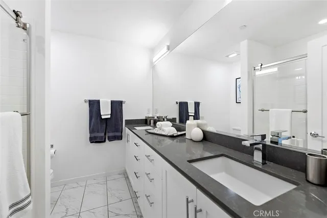 a bedroom with a bed a couch and a flat tv screen on dresser