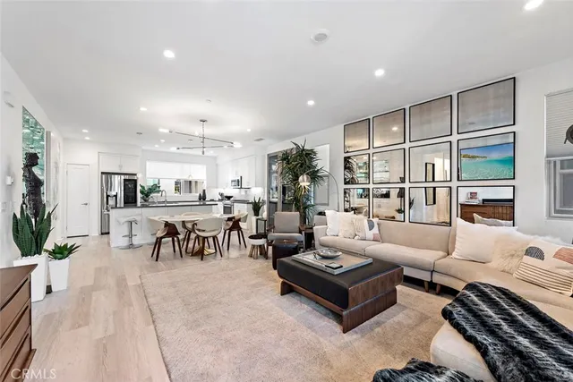 a living room with furniture kitchen view and a large window
