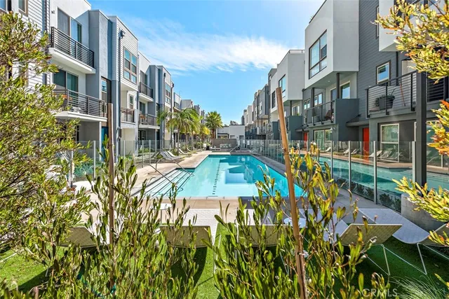 a view of a patio with couches and a fire pit and wooden fence