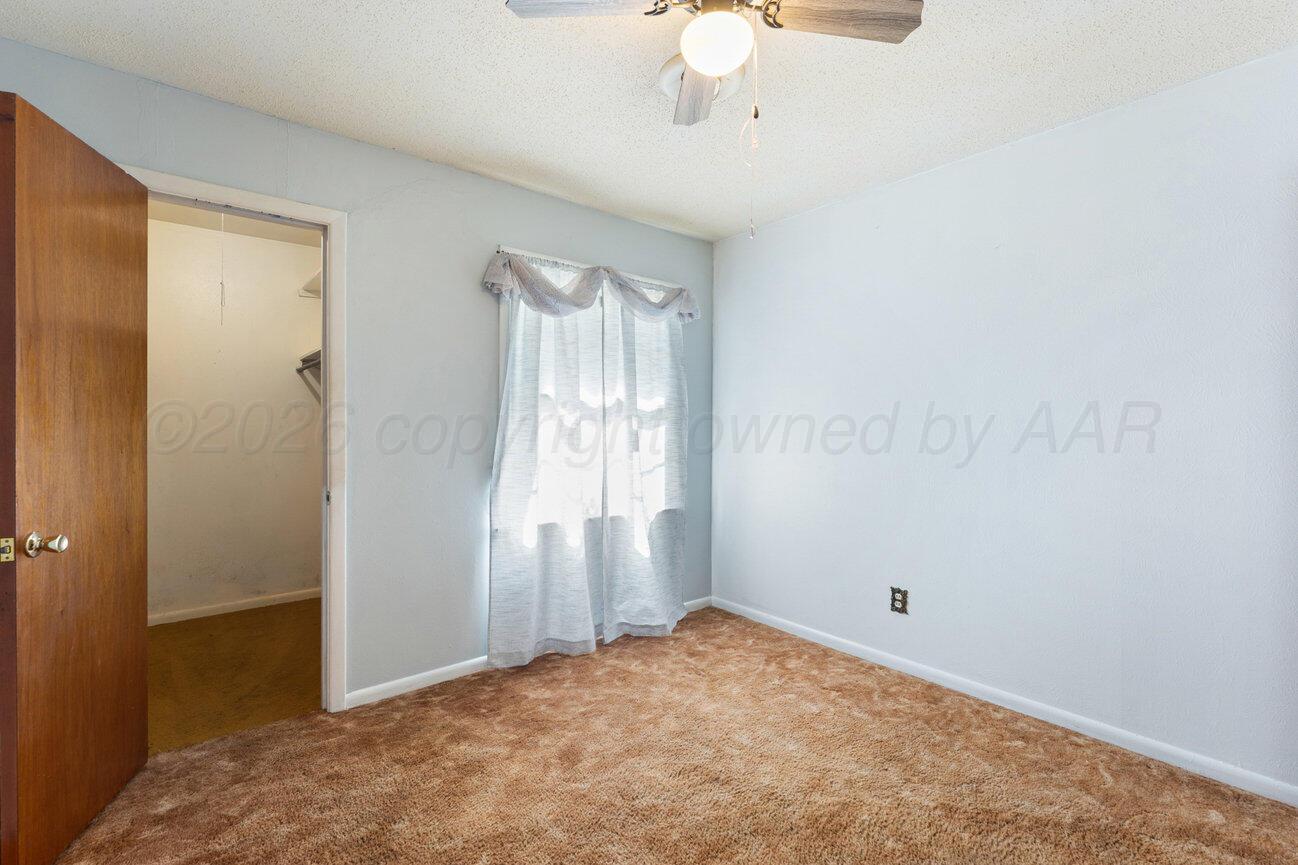 4305 South Bonham Street Amarillo, TX 79110 - Photo 32 of 48 an empty room with a chandelier fan and windows