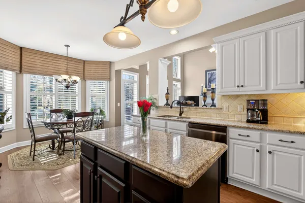 a kitchen with granite countertop a table chairs stove and cabinets