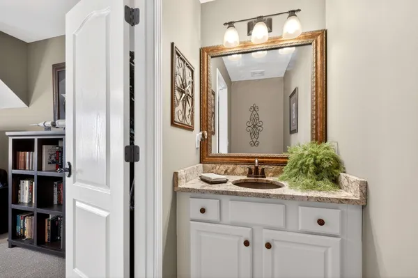 a bathroom with a granite countertop sink and a mirror