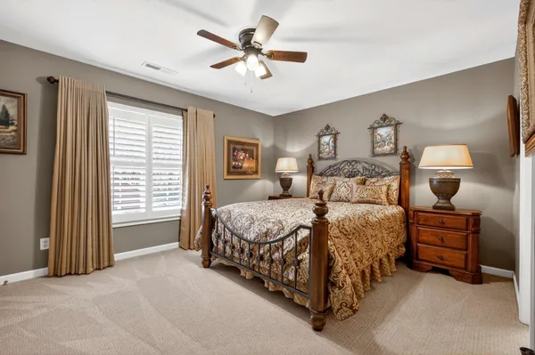 a spacious bedroom with a bed a window and a chandelier
