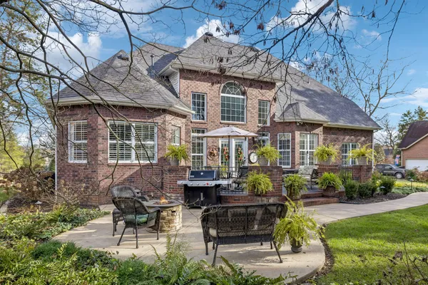 a view of a patio with table and chairs potted plants and large tree
