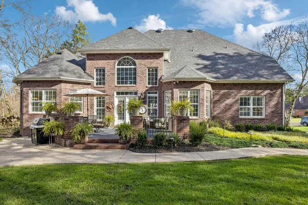 a front view of a house with a yard and potted plants