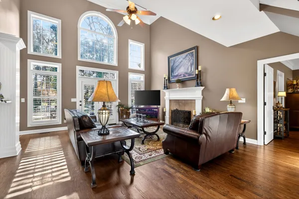 a living room with furniture a fireplace and a large window