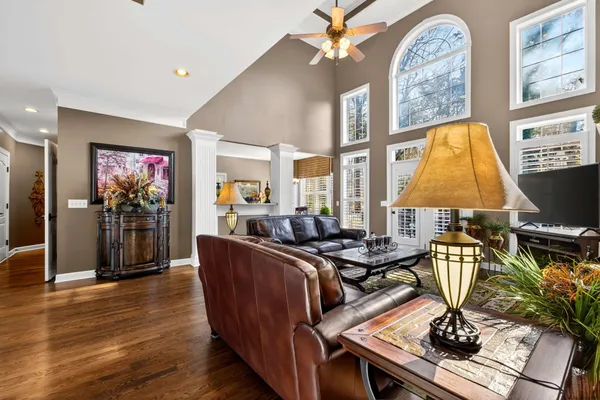 a living room with furniture a chandelier and a flat screen tv