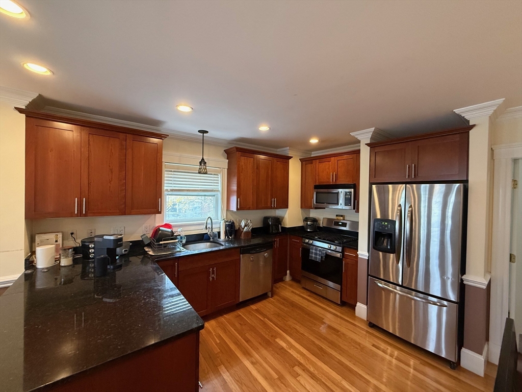72 Bennett Street, Unit 72 Boston, MA 02135 - Photo 2 of 17 a kitchen with stainless steel appliances granite countertop a refrigerator stove and sink