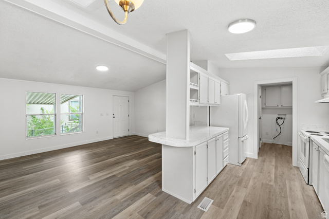 2875 North 400 West, Unit 7 Layton, UT 84041 - Photo 4 of 29 Expansive living area featuring wood-finish flooring, multiple windows, and a white entry door