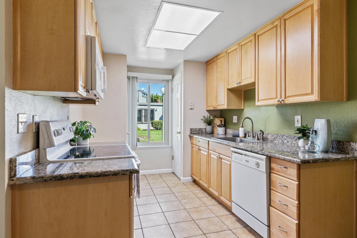 1313 Floyd Avenue, Unit 179 Modesto, CA 95355 - Photo 11 of 28 a kitchen with granite countertop a sink a stove and cabinets