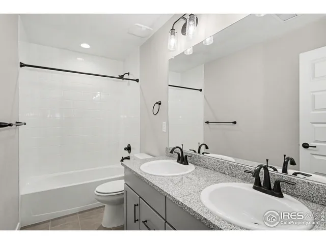 a bathroom with a granite countertop sink a toilet a mirror and shower