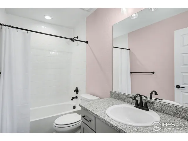 a bathroom with a granite countertop sink toilet a shower and a mirror
