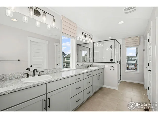 a bathroom with a double vanity sink mirror and shower