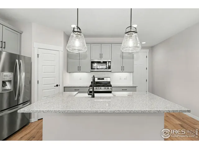 a kitchen with stainless steel appliances granite countertop a sink refrigerator and microwave