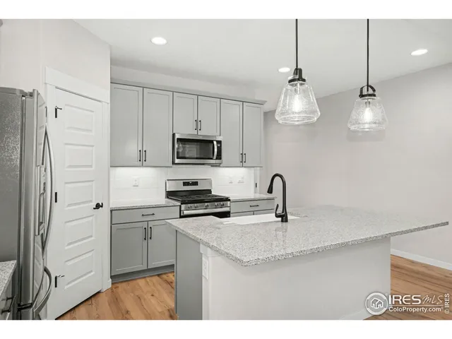 a kitchen with stainless steel appliances a sink a refrigerator a stove a microwave and cabinets