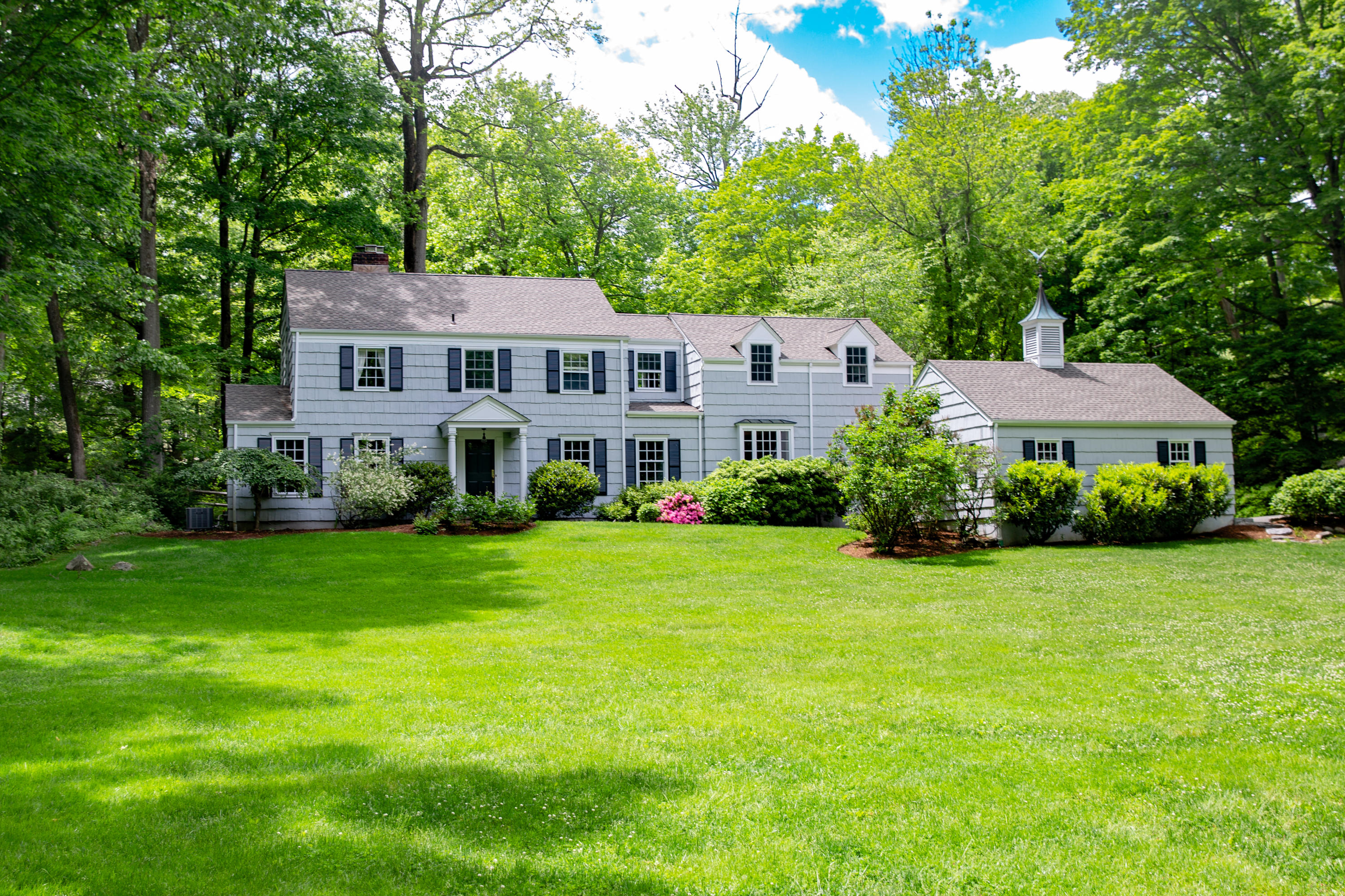 a front view of a house with yard and green space