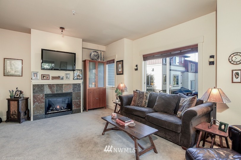 2115 201st Place Southeast, Unit F1 Bothell, WA 98012 - Photo 4 of 10 a living room with furniture a flat screen tv and a fireplace