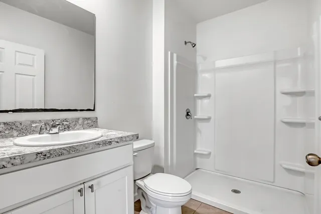 a bedroom with a bed and a flat tv screen on wall