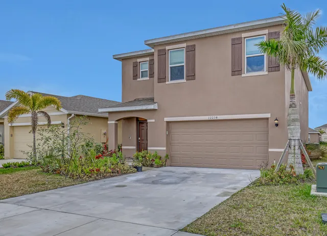 a front view of a house with a yard and garage