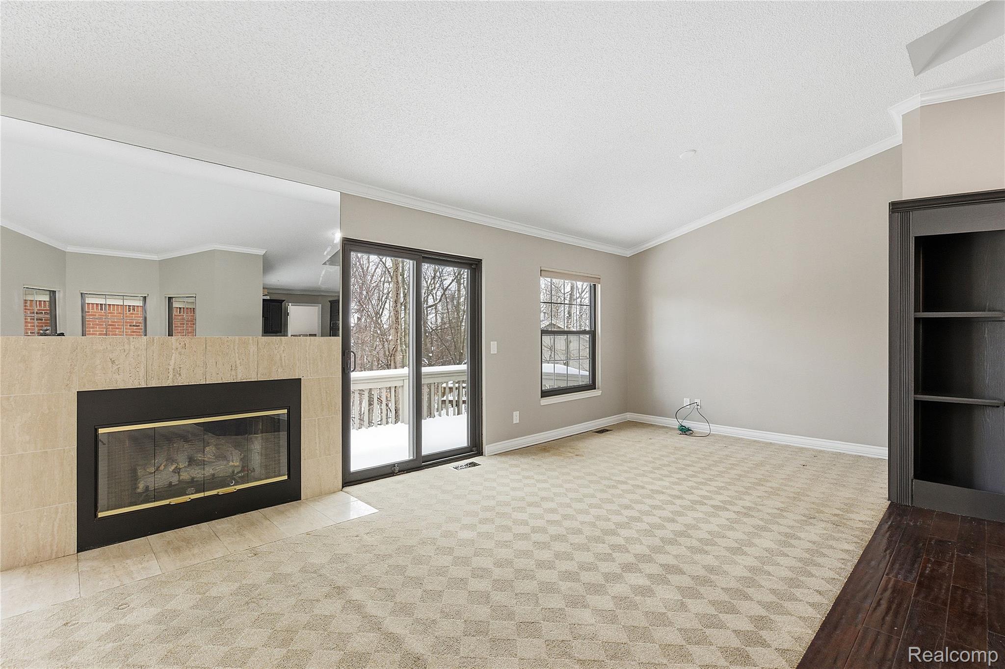 7154 Westchester Road West Bloomfield, MI 48322 - Photo 7 of 38 Unfurnished living room with crown molding, a fireplace, a textured ceiling, and wood finished floors